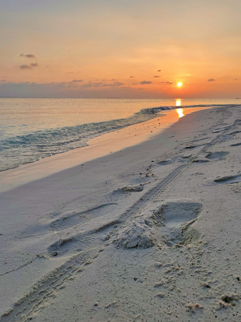 sea waves crashing on shore during sunset