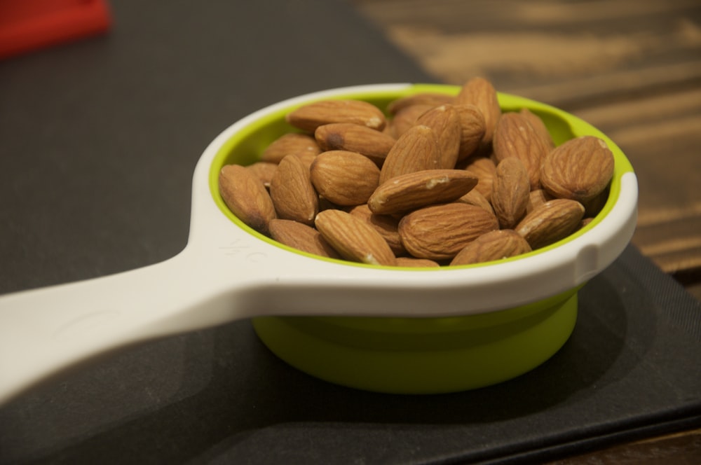 brown nuts in green ceramic bowl
