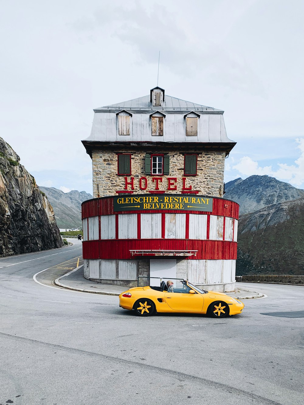 yellow ferrari coupe on road near red and white building during daytime