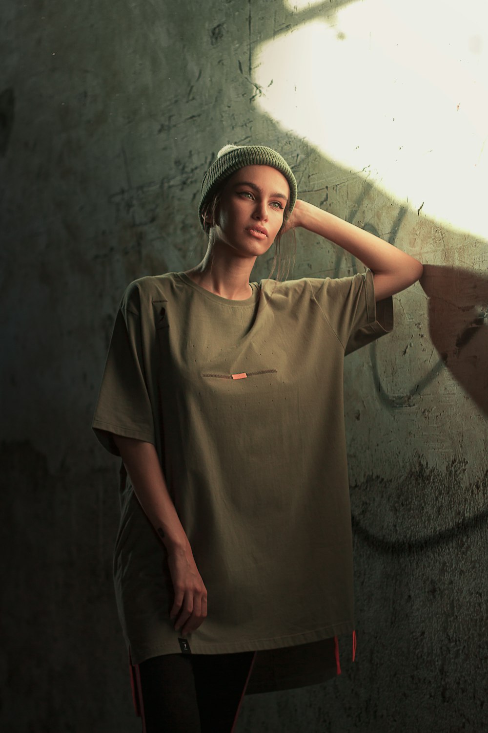 girl in brown crew neck t-shirt standing on gray concrete floor