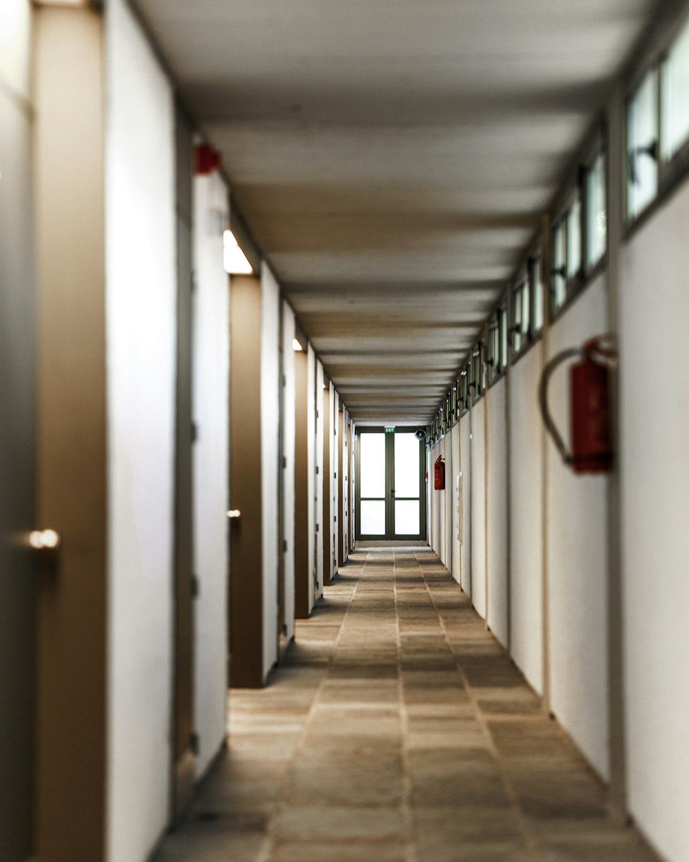 white hallway with red fire extinguisher