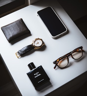 black framed eyeglasses beside black leather bifold wallet and black leather bifold wallet