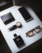 black framed eyeglasses beside black leather bifold wallet and black leather bifold wallet