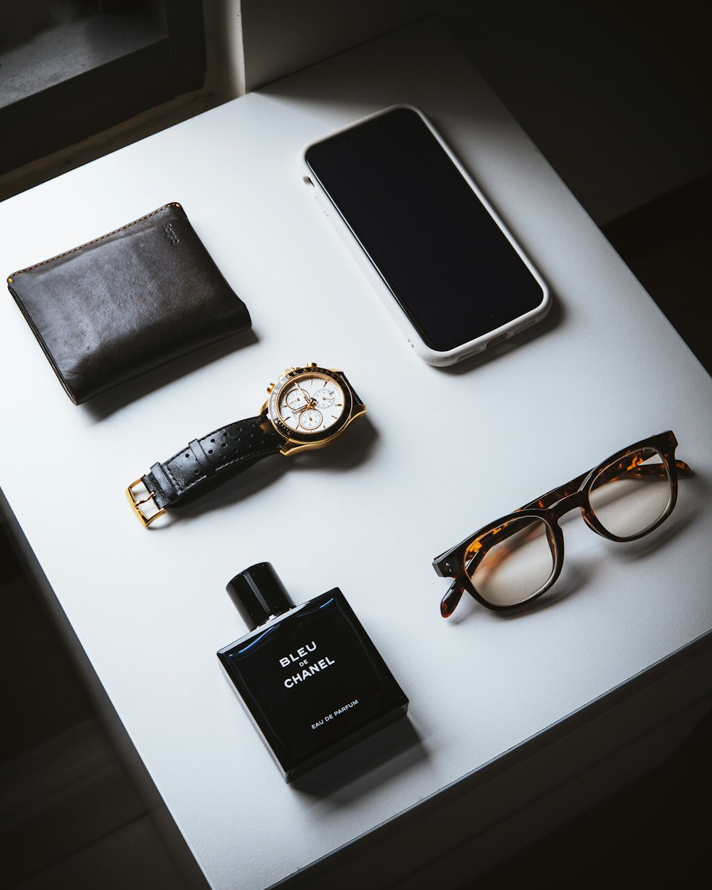 black framed eyeglasses beside black leather bifold wallet and black leather bifold wallet