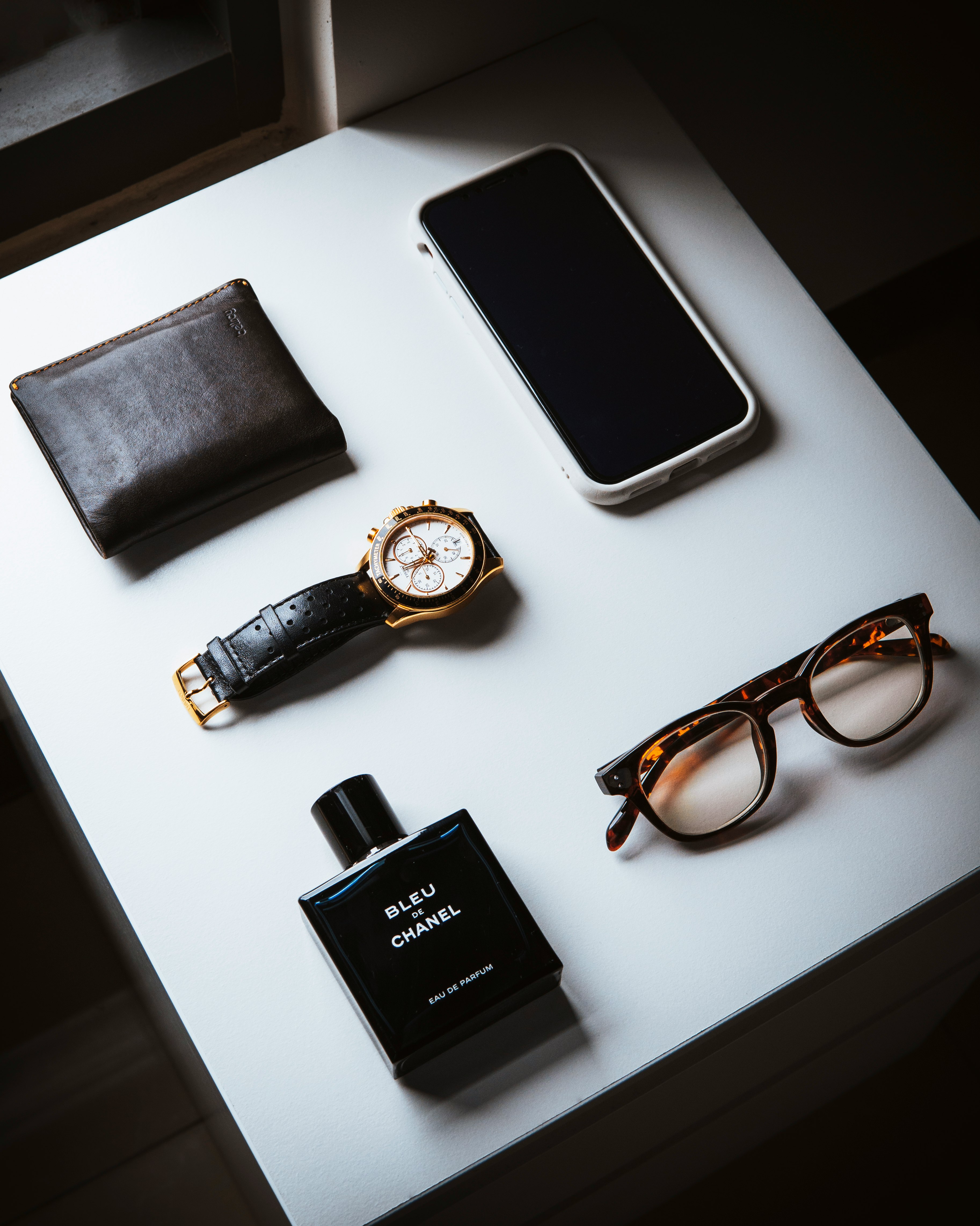 black framed eyeglasses beside black leather bifold wallet and black leather bifold wallet