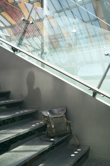 A sleek ergonomic backpack resting on a wooden bench, sunlight filtering through leaves above.
