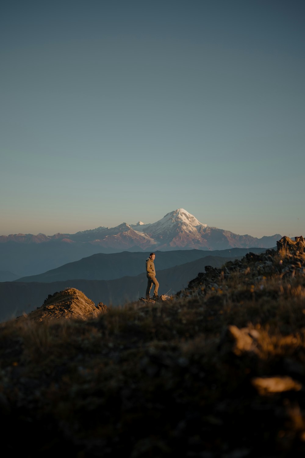 person standing on green grass field near mountain during daytime