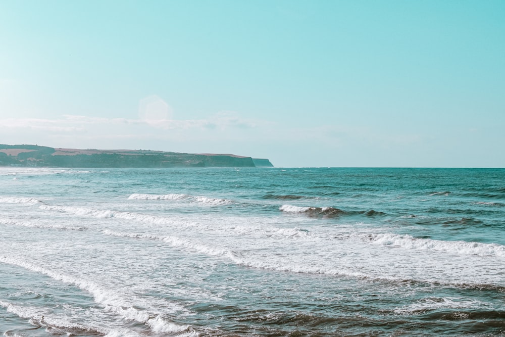 ocean waves crashing on shore during daytime