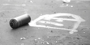 Close-up of a spray paint can and stencil used in a workshop on a dark urban backdrop