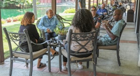 people sitting on black metal chairs during daytime