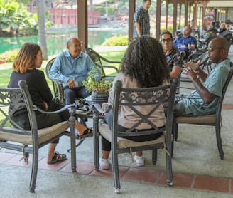 people sitting on black metal chairs during daytime