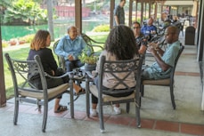 people sitting on black metal chairs during daytime