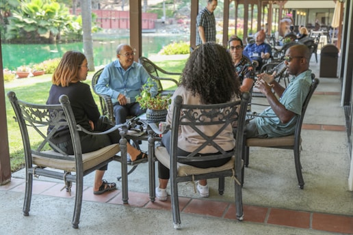 people sitting on black metal chairs during daytime