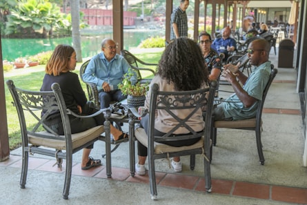 people sitting on black metal chairs during daytime