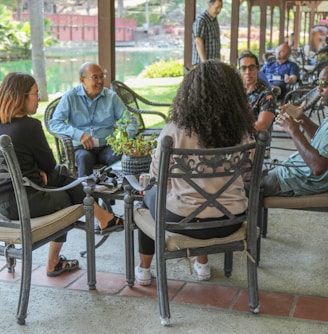 people sitting on black metal chairs during daytime