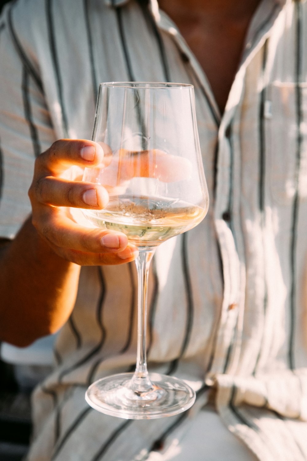 person holding clear wine glass