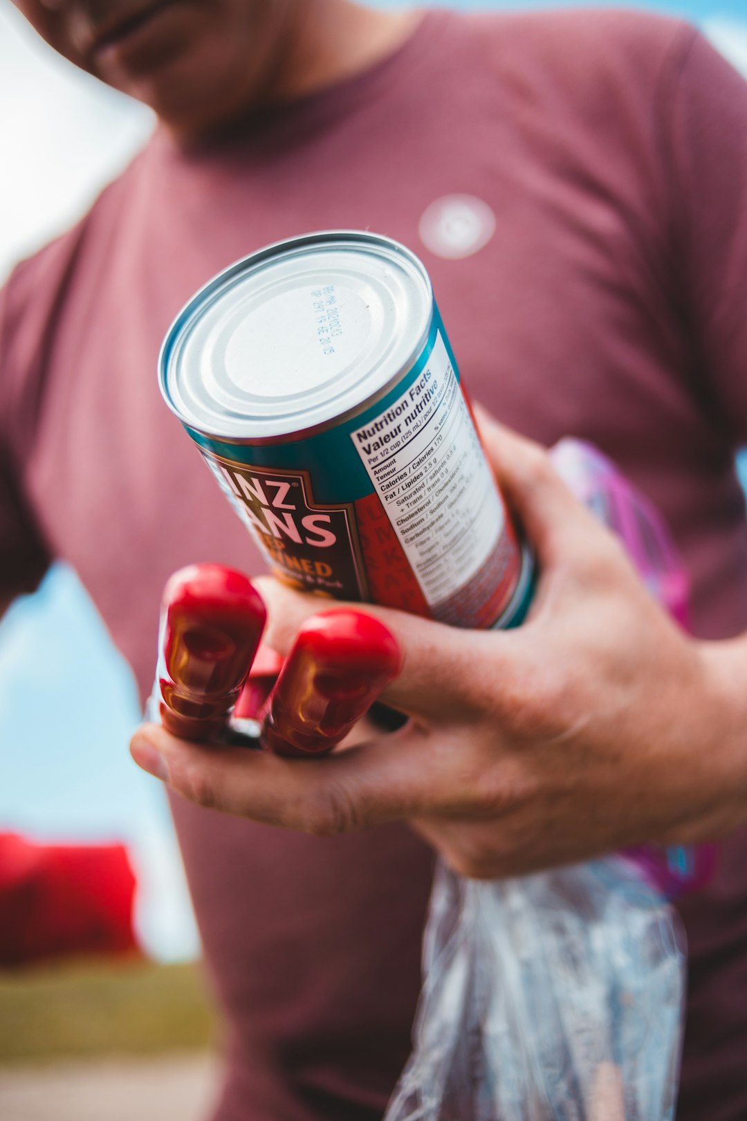 person holding red and white can