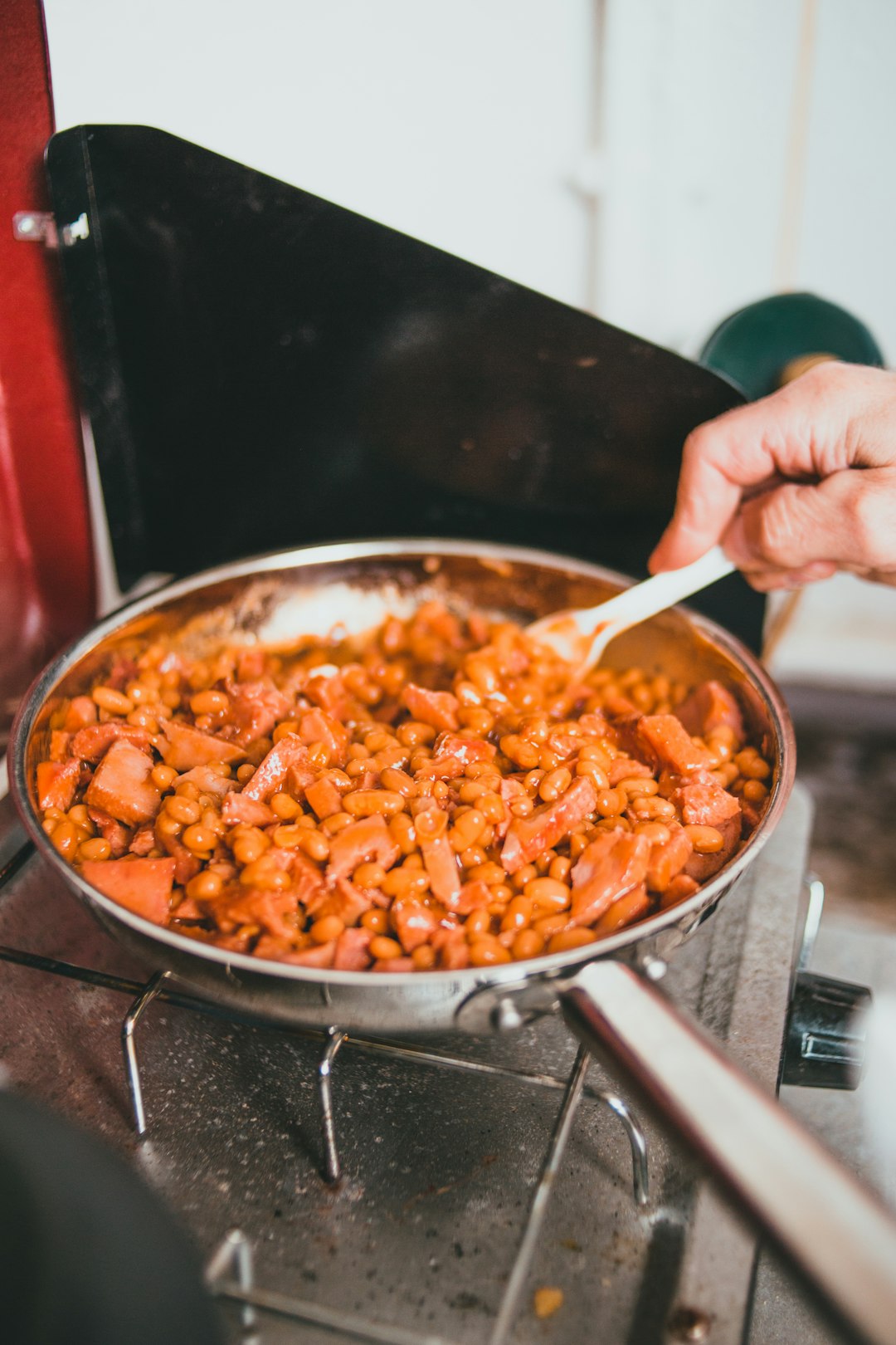 person holding stainless steel bowl with brown food