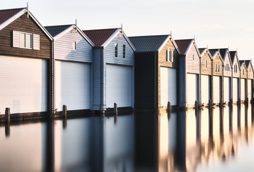 white and brown wooden house on water