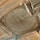 An ornate interior ceiling features a large, circular centerpiece with intricate carvings and golden accents. The ceiling is wooden, with a radial pattern emanating from the center. Surrounding the circle are decorative moldings and arches, all with detailed embellishments.
