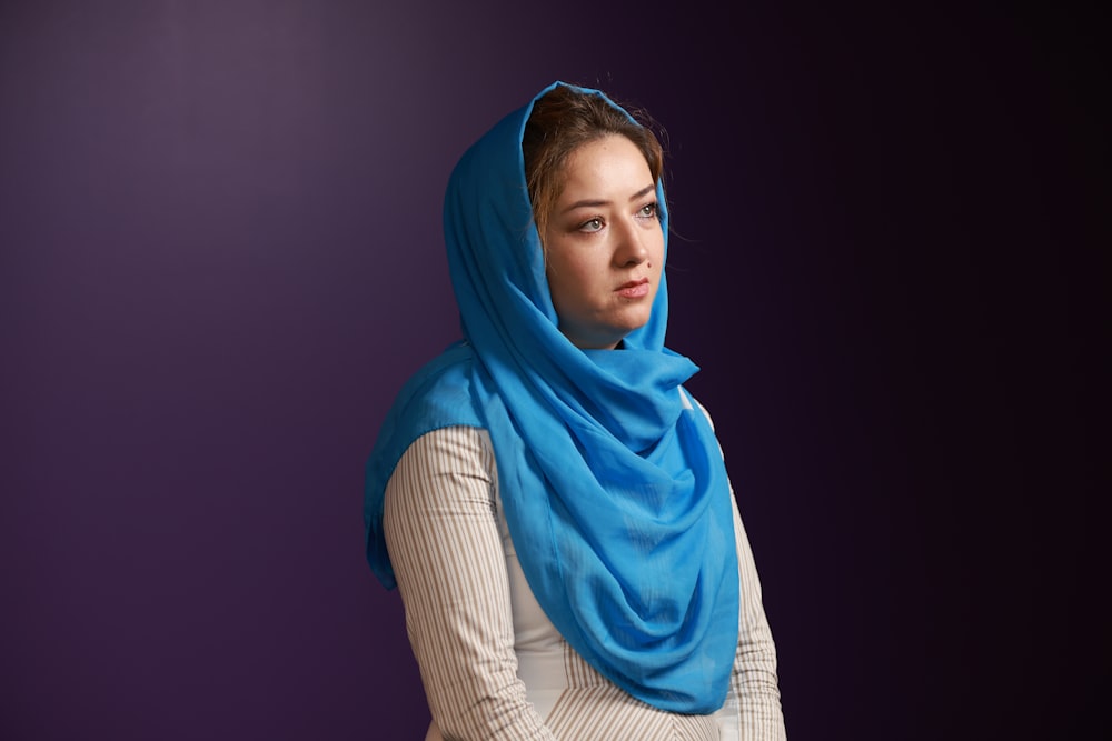Mujer con hiyab azul y camisa blanca de manga larga
