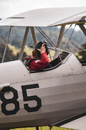 man in red jacket riding on white and black plane during daytime