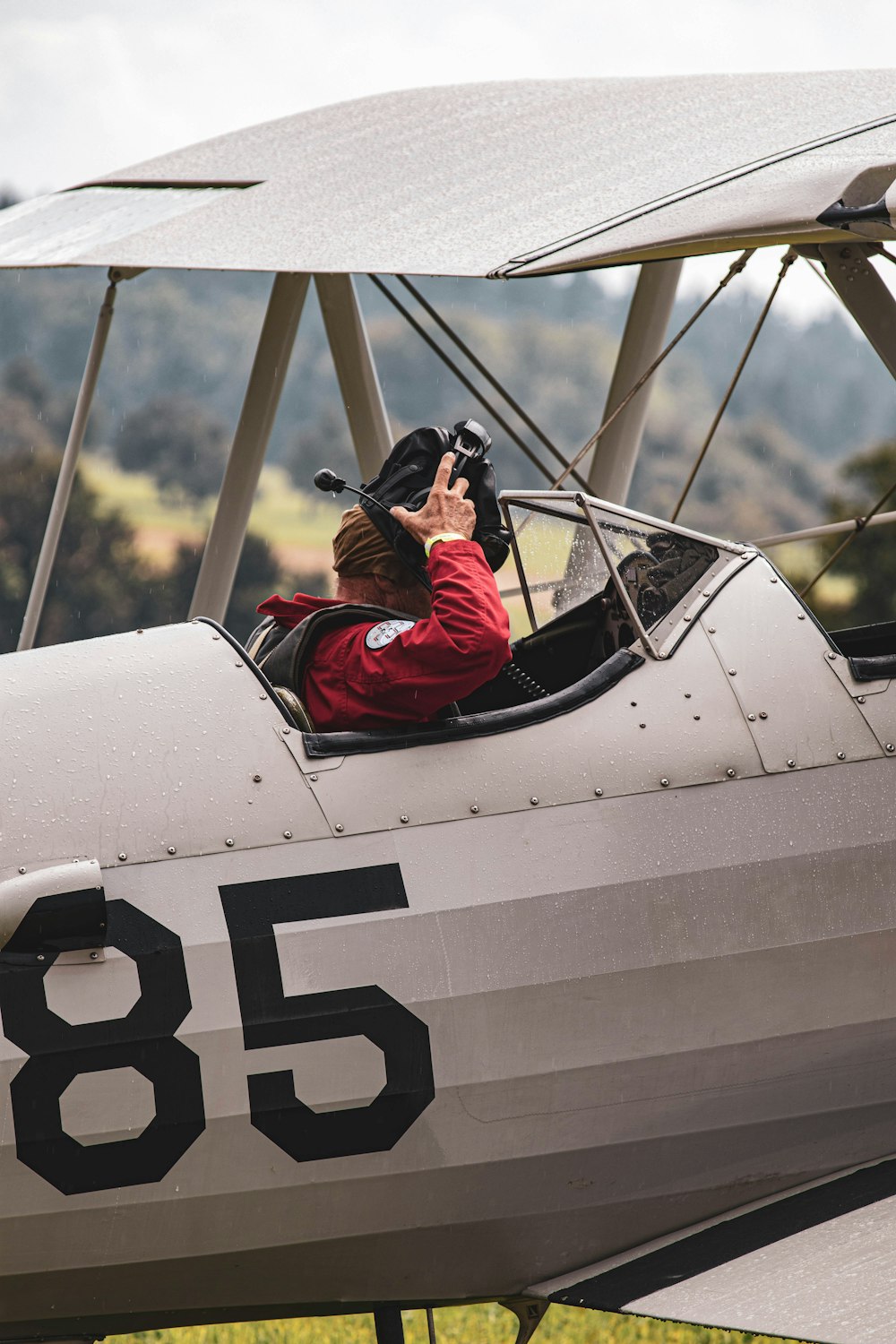 man in red jacket riding on white and black plane during daytime