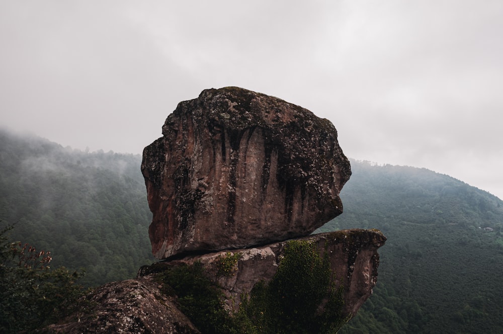 brown rock formation on body of water during daytime