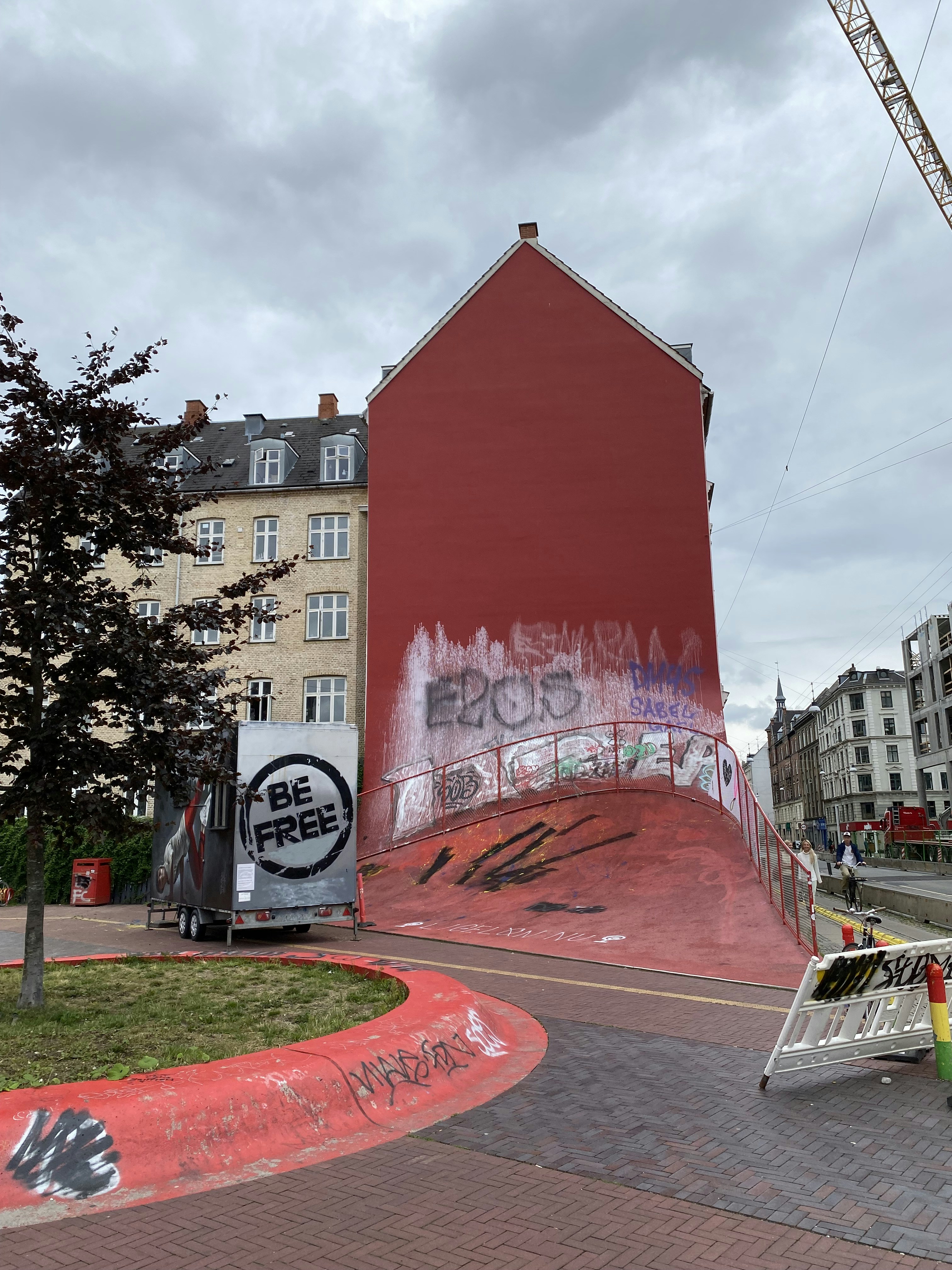 red and white concrete building near green trees under white clouds and blue sky during daytime
