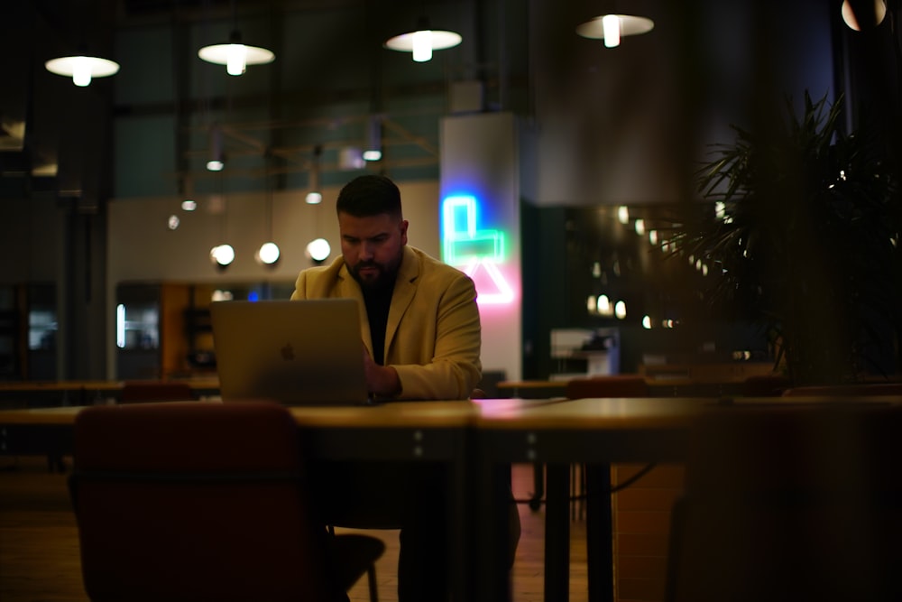 man in brown suit jacket sitting on chair