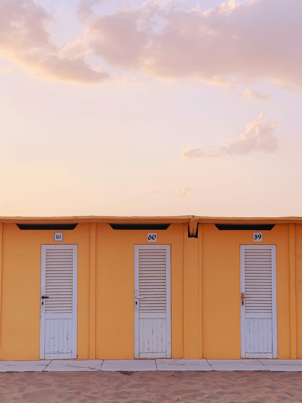 yellow and white wooden house under white clouds during daytime