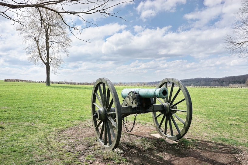 Historic cannon resting on the Antietam battlefield under a cloudy sky.