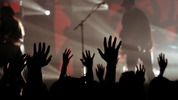 Close-up of hands raised in worship during a live concert.