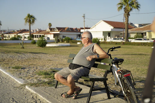 man in gray t-shirt sitting on black wooden bench during daytime