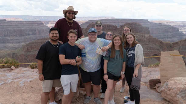 A group of happy French-speaking tourists exploring the Grand Canyon with a scenic backdrop.