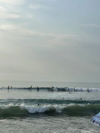 Surfers catching waves near the beach close to Jesolo Resort Arugambay.