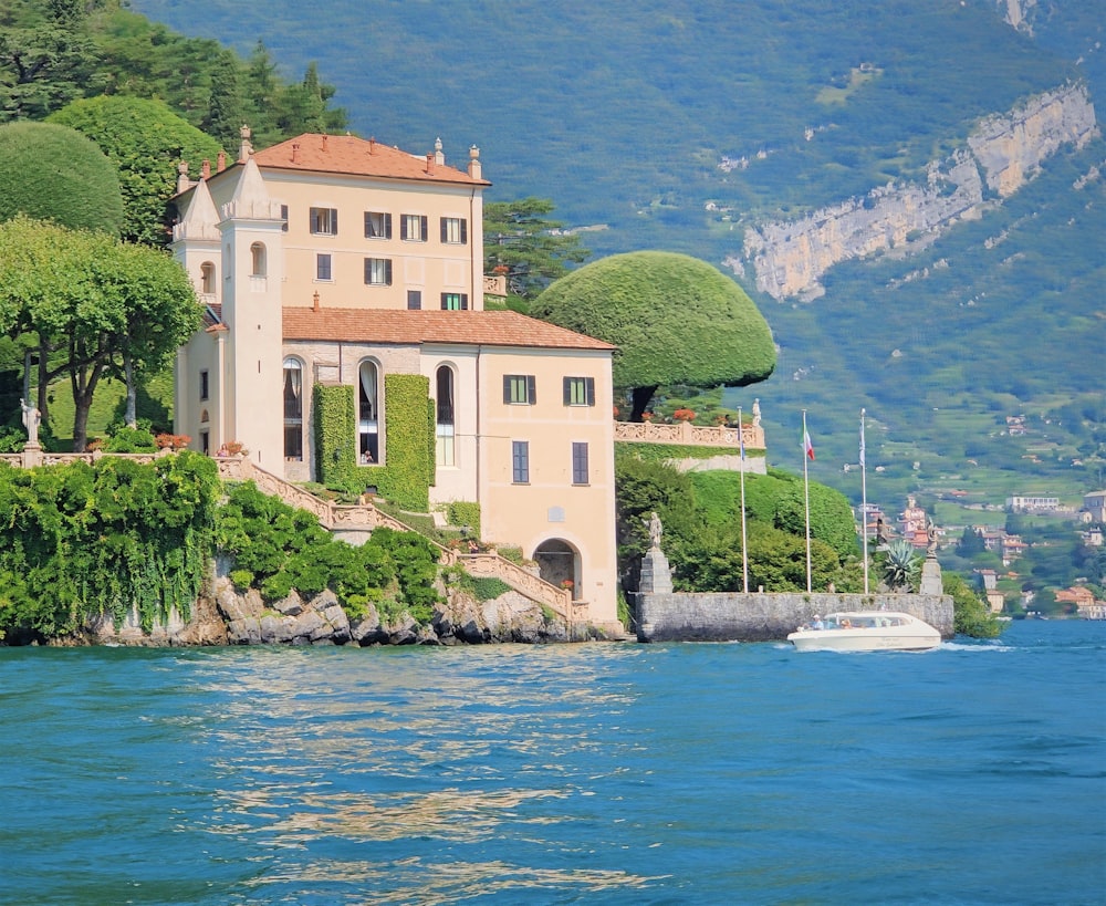 white boat on water near green trees and buildings during daytime