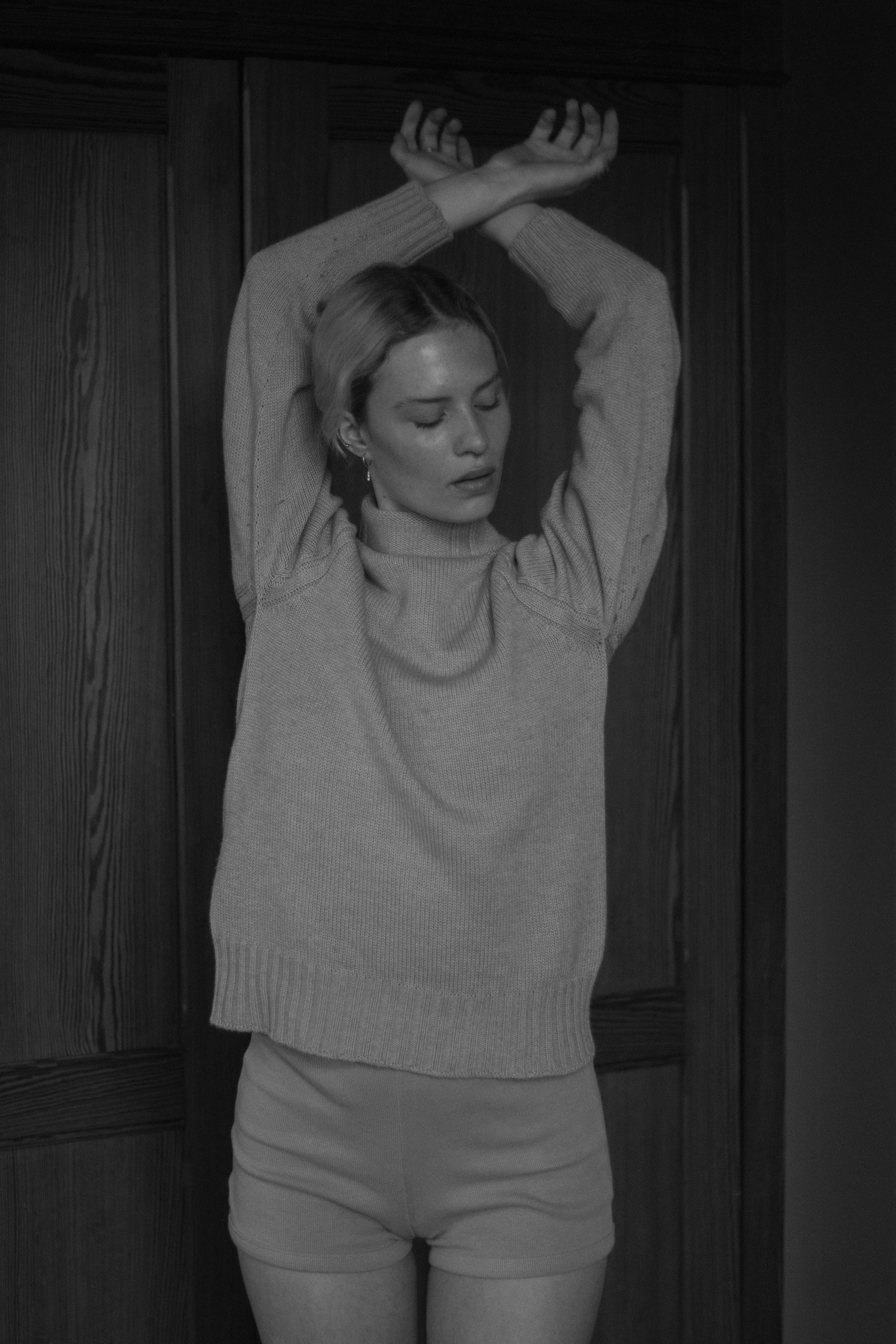 mujer con suéter gris que cubre su rostro