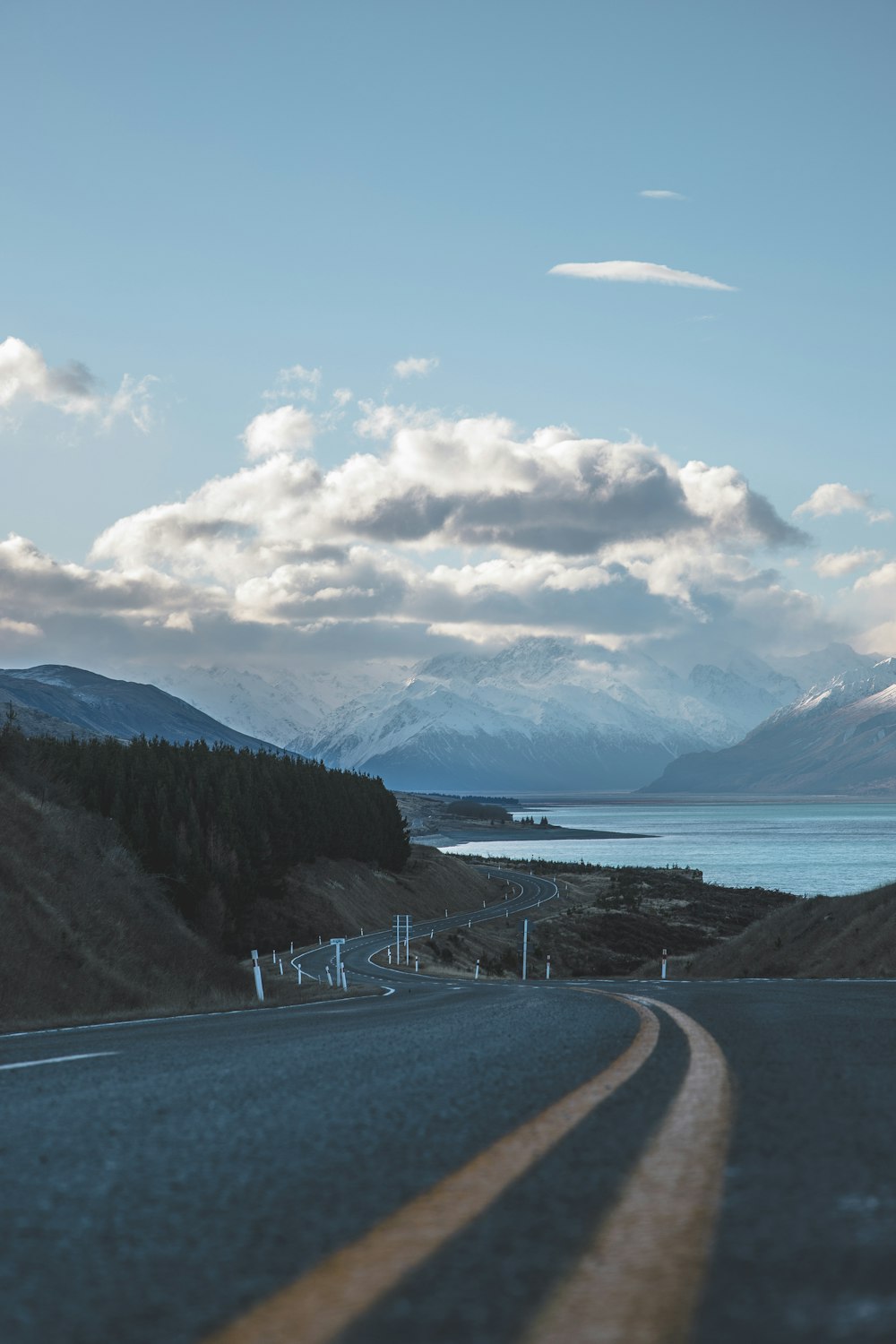 gray asphalt road near body of water during daytime