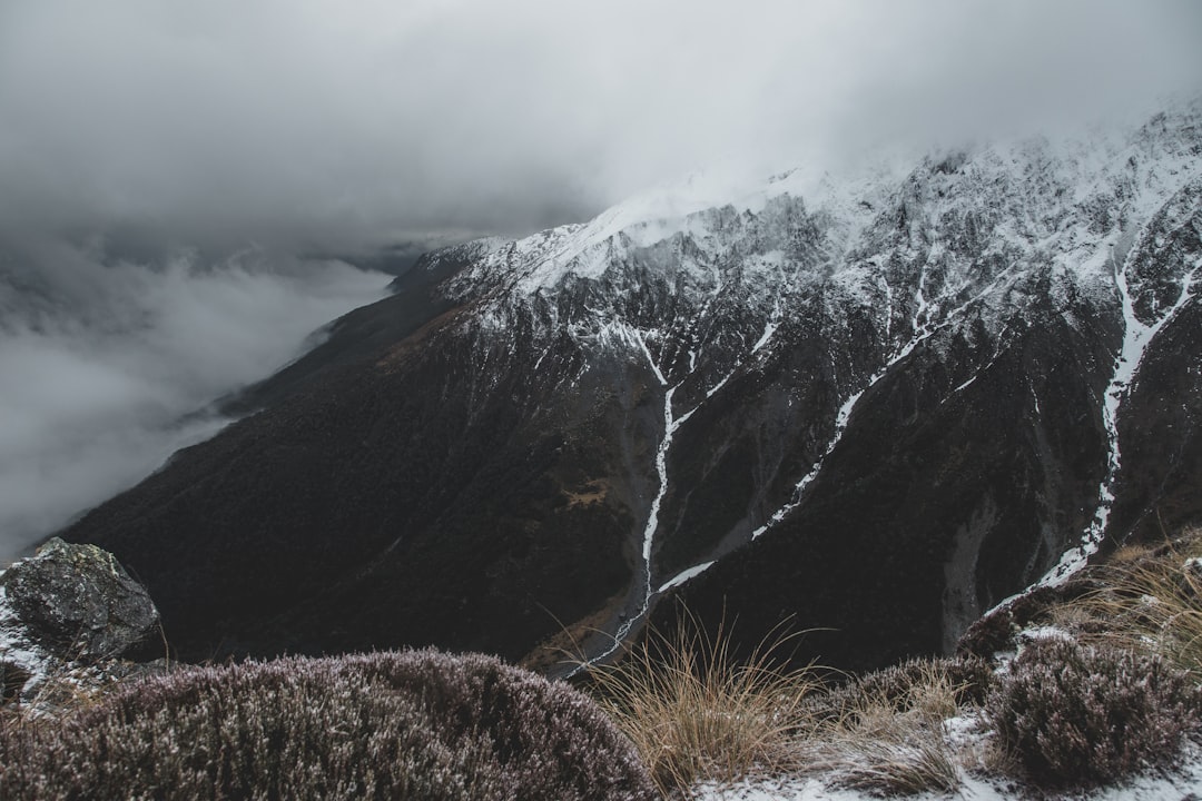 brown and white mountain under white clouds