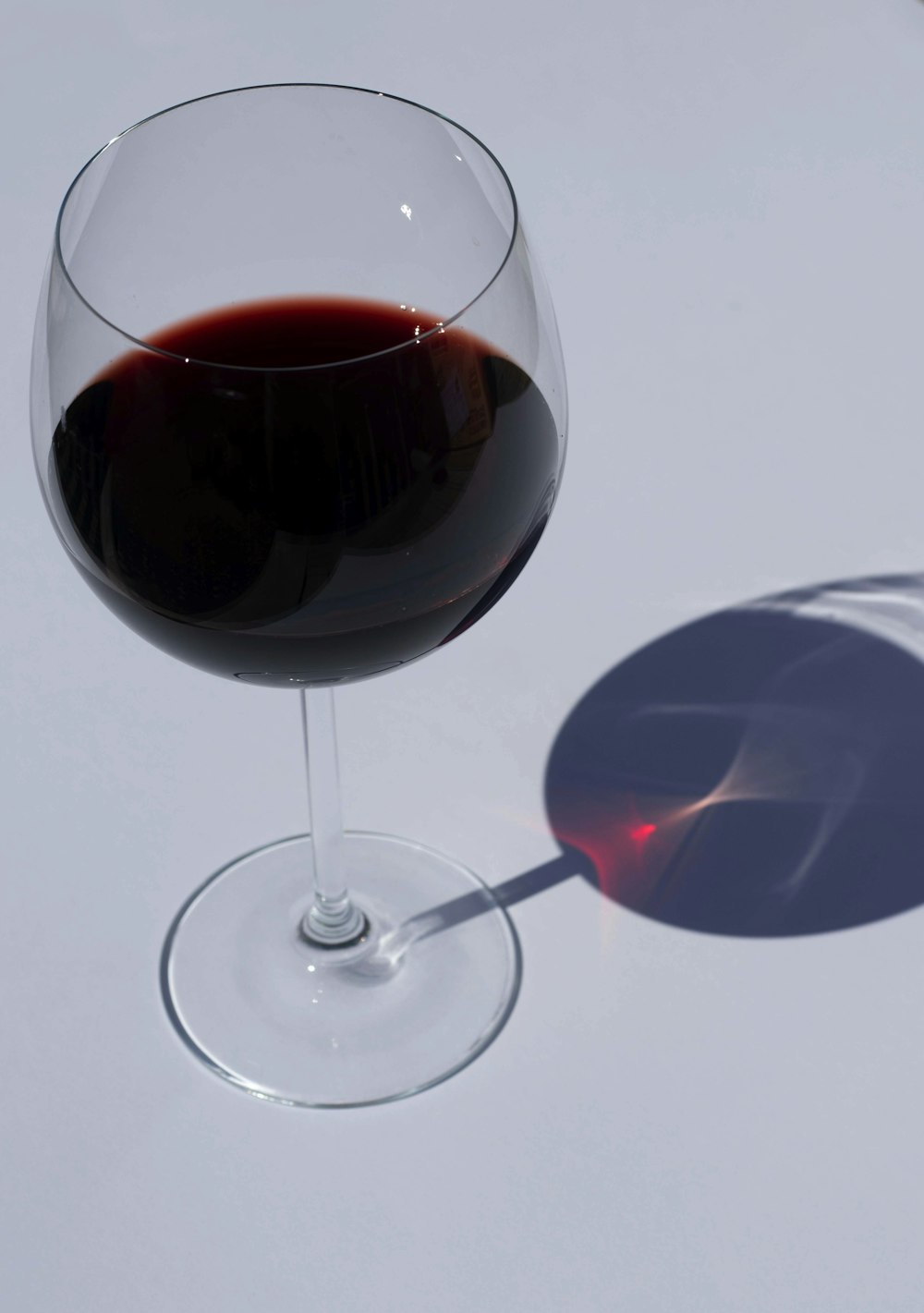 verre à vin transparent avec du vin rouge