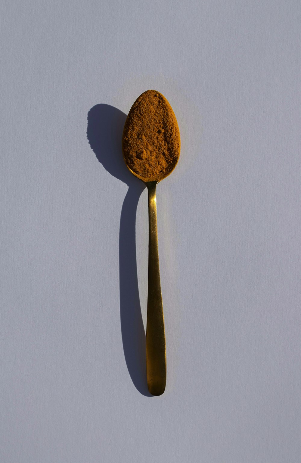 brown wooden spoon on white table