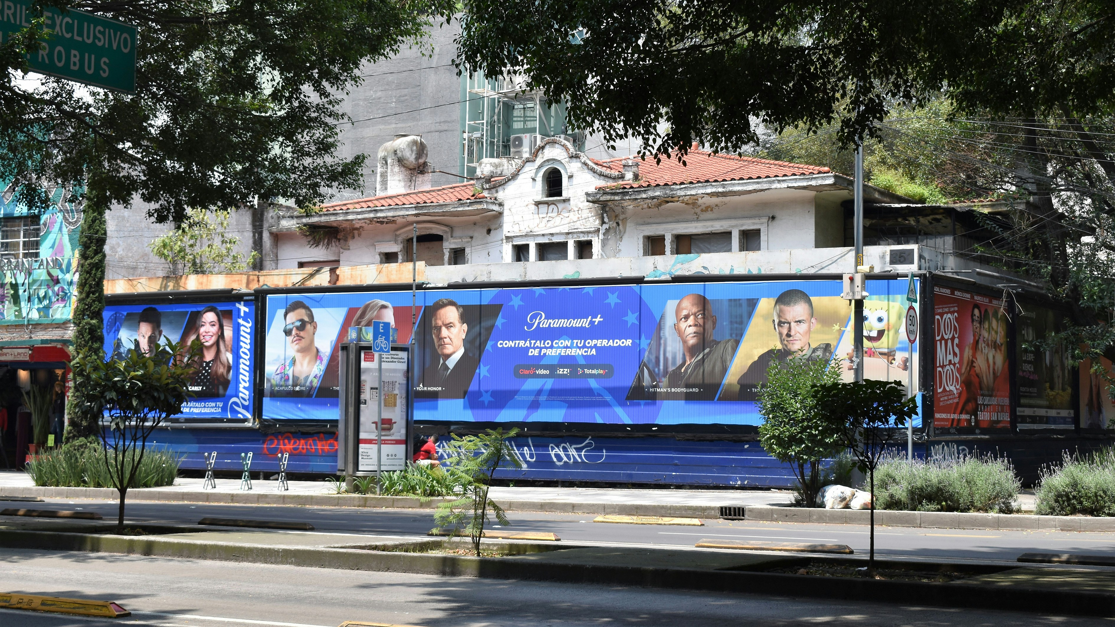 3 men standing beside blue and white building during daytime
