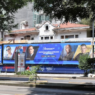 3 men standing beside blue and white building during daytime