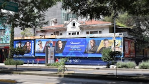 3 men standing beside blue and white building during daytime