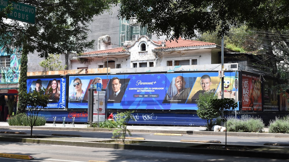 3 men standing beside blue and white building during daytime