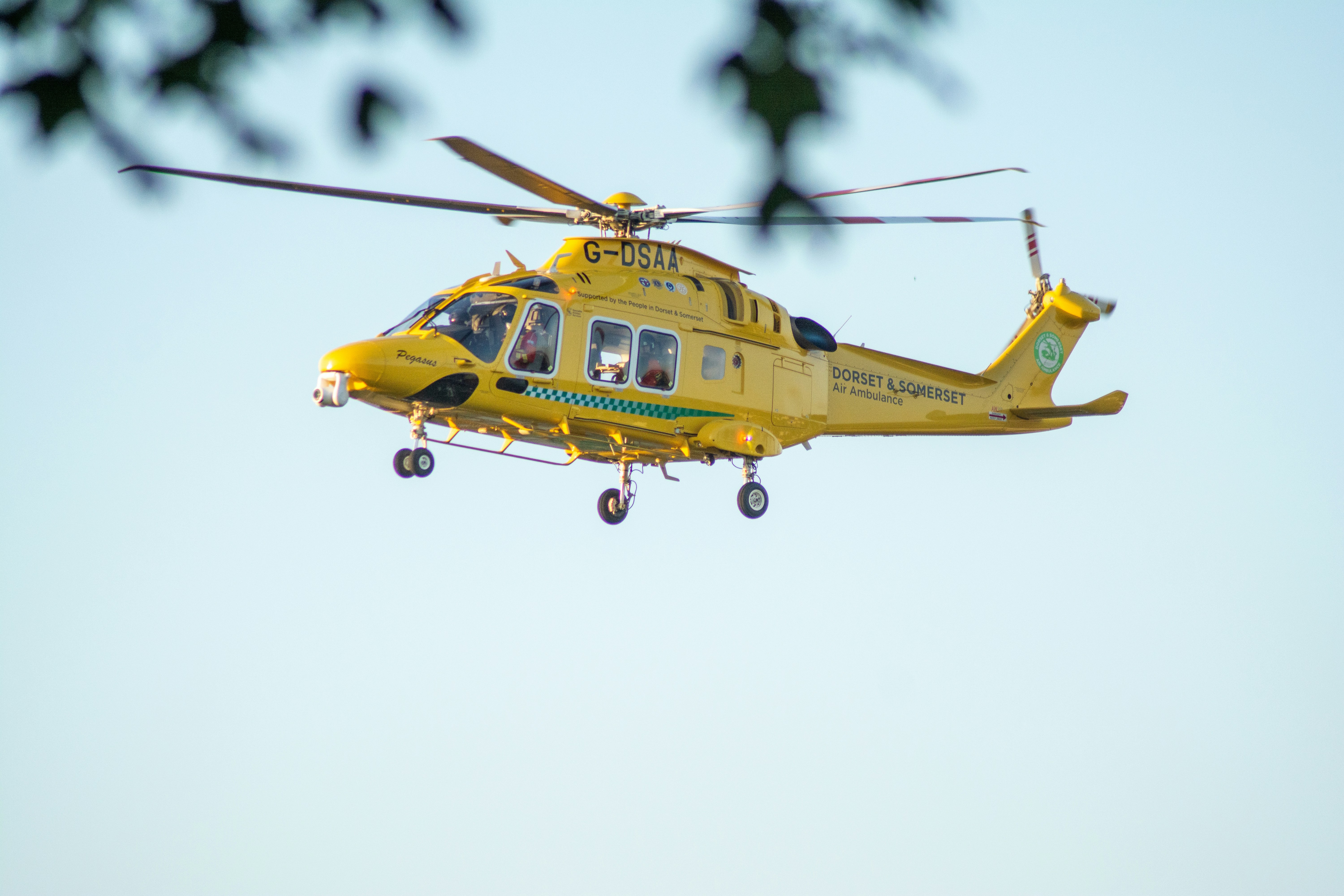 yellow and black helicopter flying in the sky