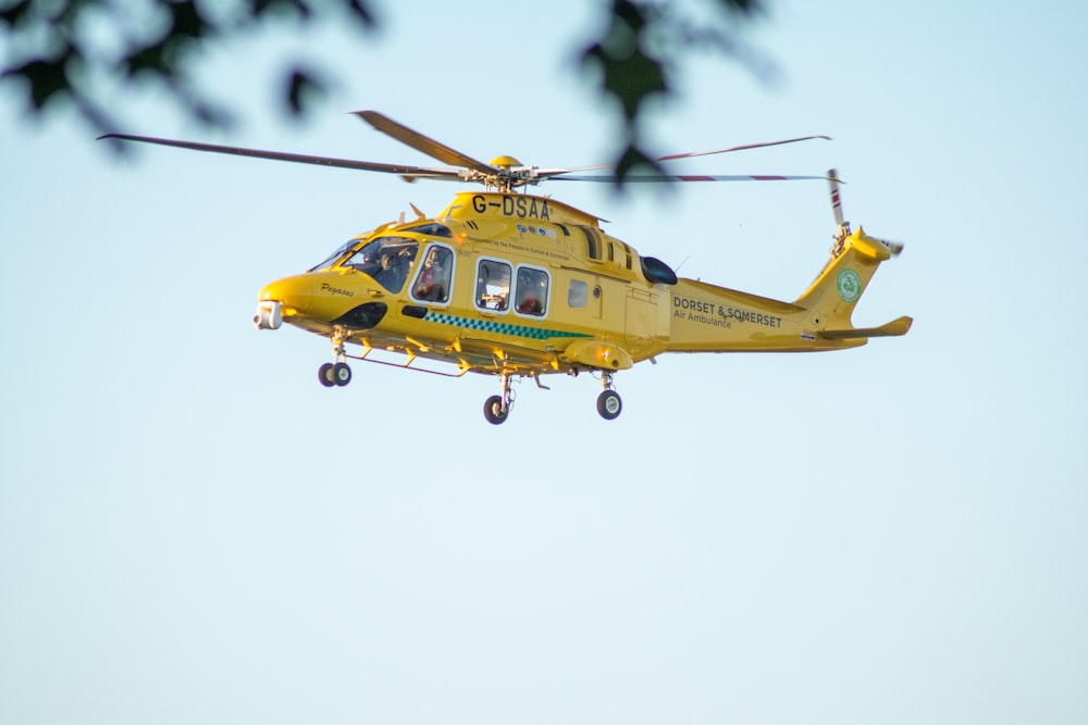 yellow and black helicopter flying in the sky