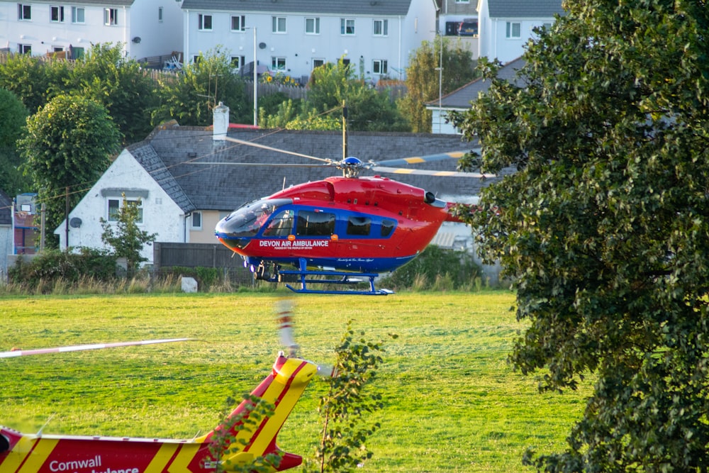 red and yellow helicopter on green grass field during daytime