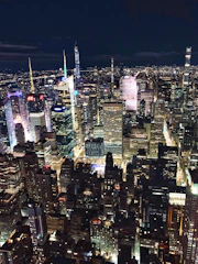 A bustling cityscape at night with illuminated skyscrapers and lively streets.